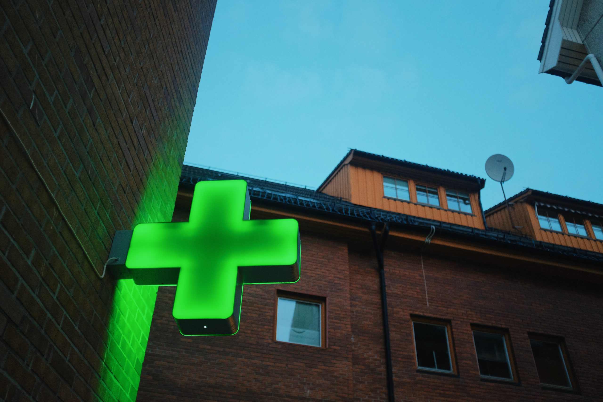 green neon cross pharmacy hospital sign on a buil 2021 12 09 09 44 53 utc scaled